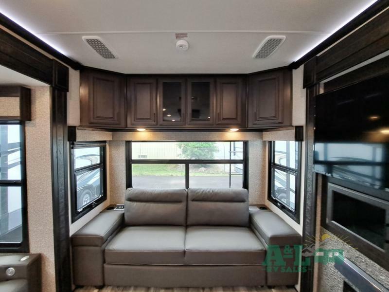 Living space with leather seats and overhead cabinets.