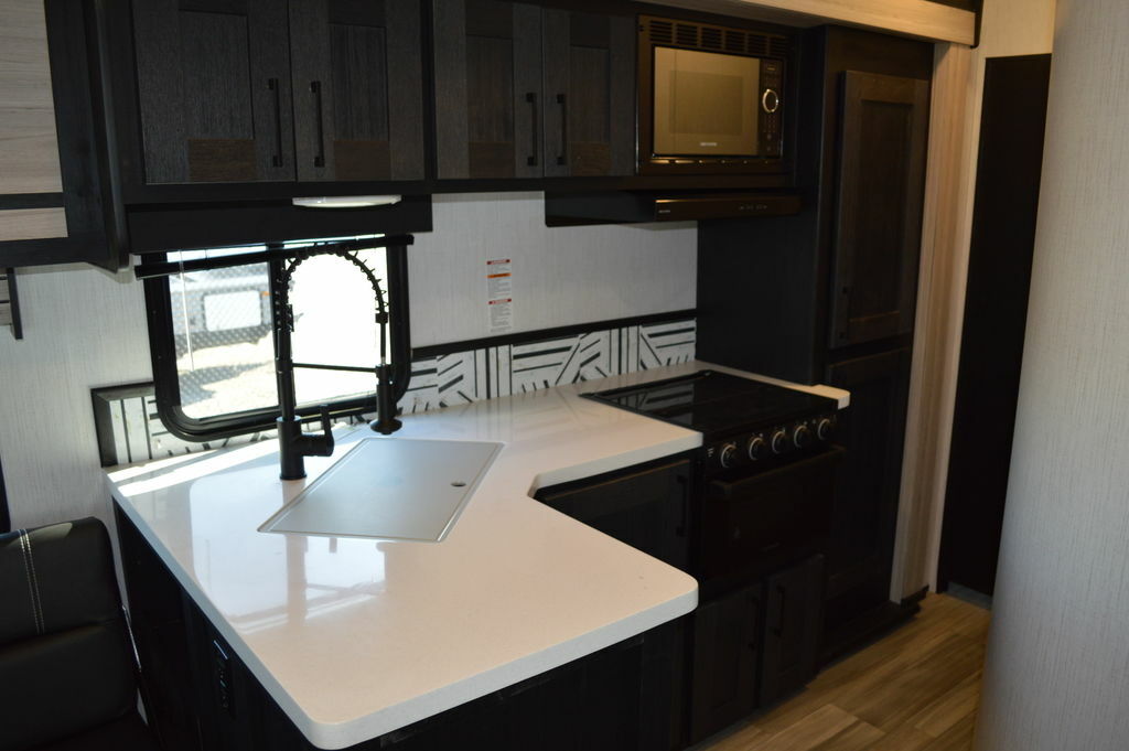 Kitchen with a gas burner, oven, sink and cabinets.