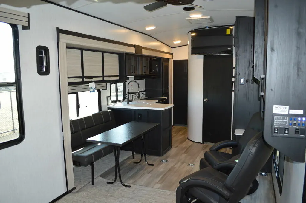 Interior view of the RV with a dinette, living space and a kitchen.