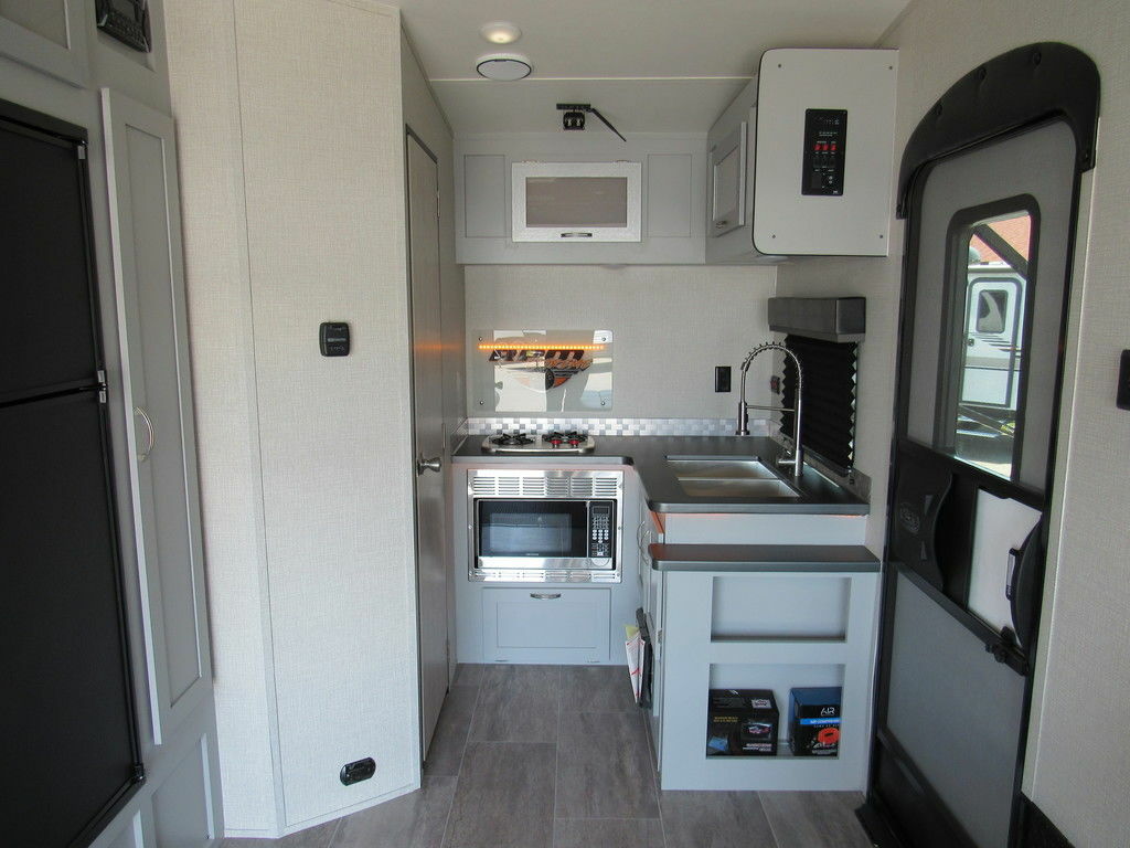 Kitchen with a gas burner, oven, sink and cabinets.