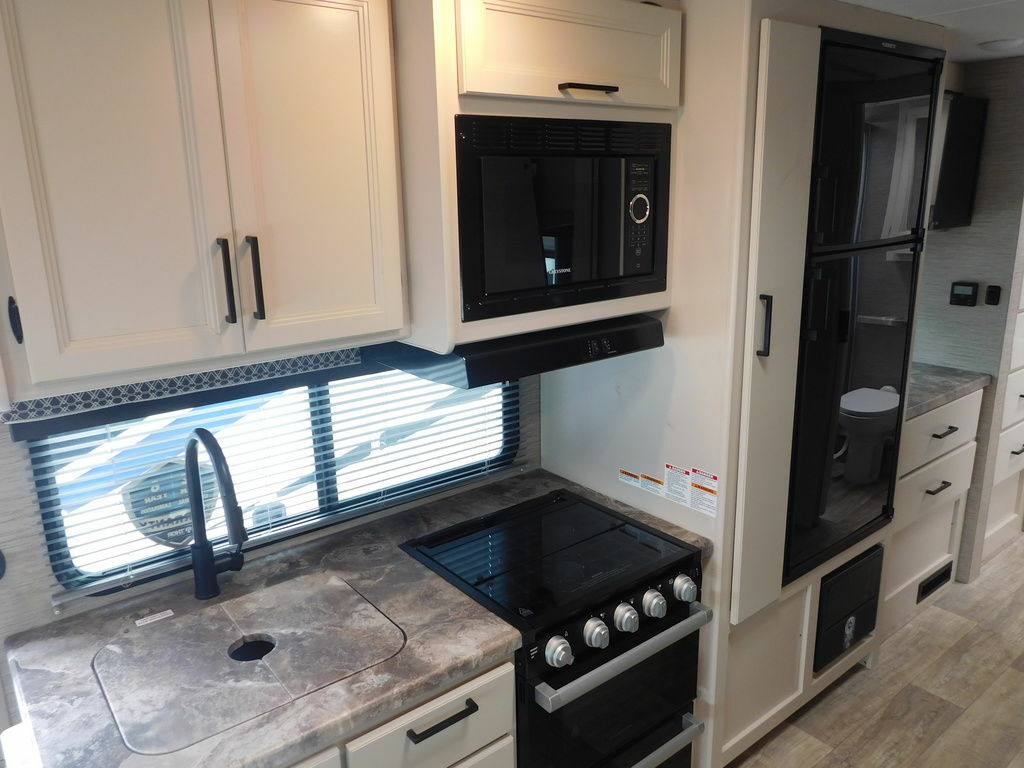 Kitchen with a gas burner, fridge, oven, sink and cabinets.