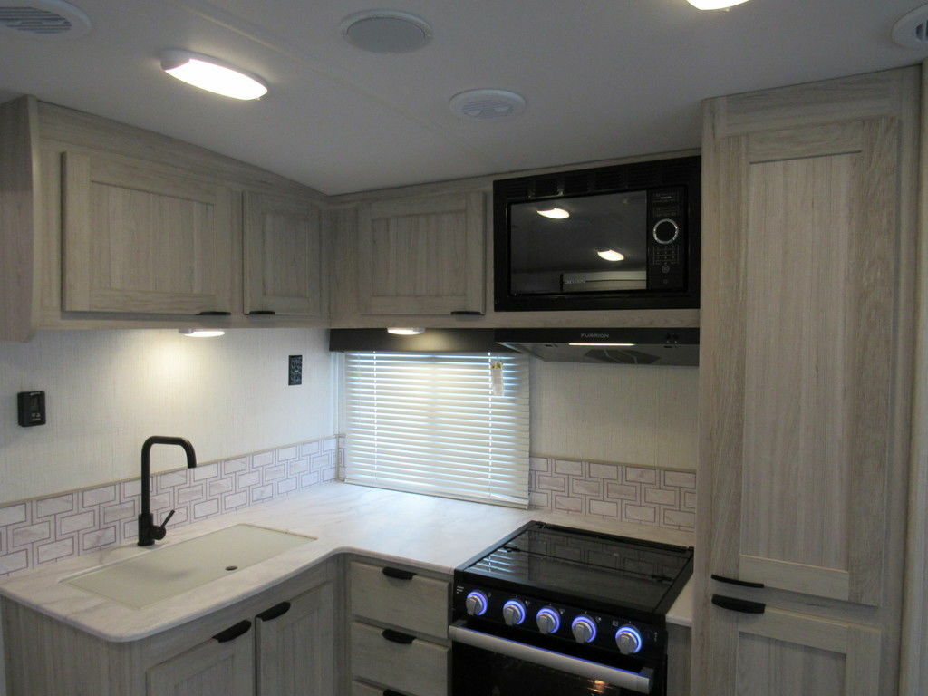 Kitchen with a gas burner, oven, sink and cabinets.