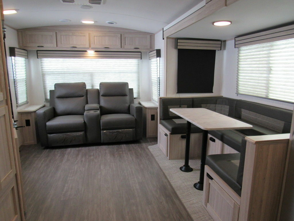 Interior view of the RV with a dinette and a living space.