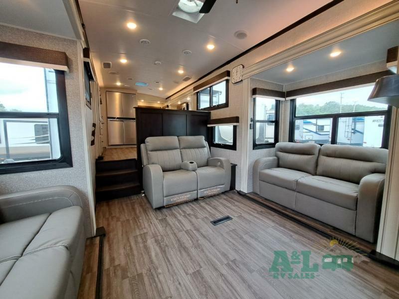 Interior view of the RV with a dinette, living space and a kitchen.