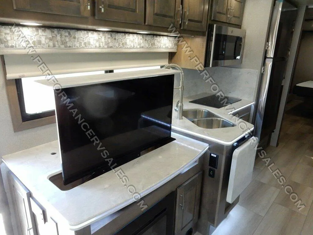 Kitchen with a fridge, oven, sink and cabinets.