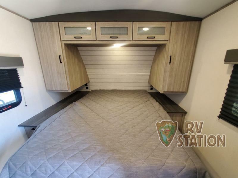 Bedroom with a queen size bed, overhead cabinets and a shirt closet.