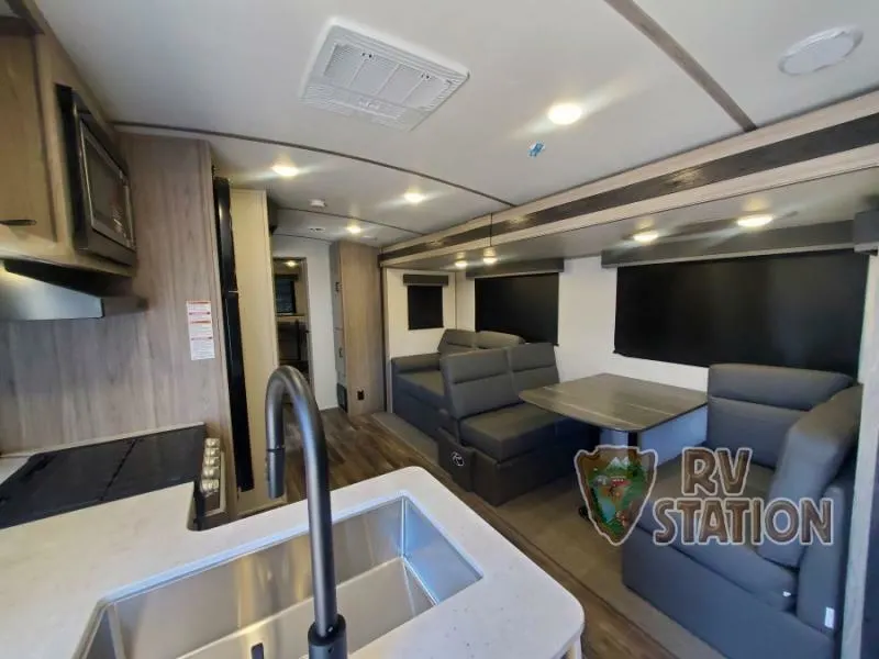 Interior view of the RV with a dinette, living space and a kitchen.