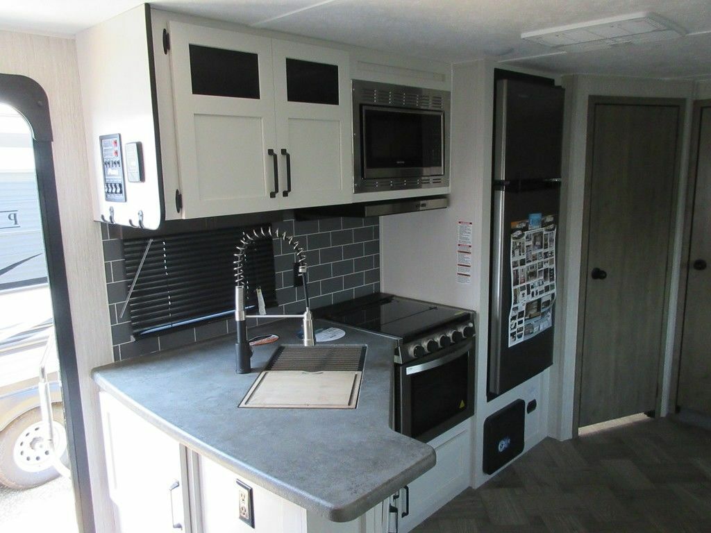 Kitchen with a gas burner, fridge, oven, sink and cabinets.