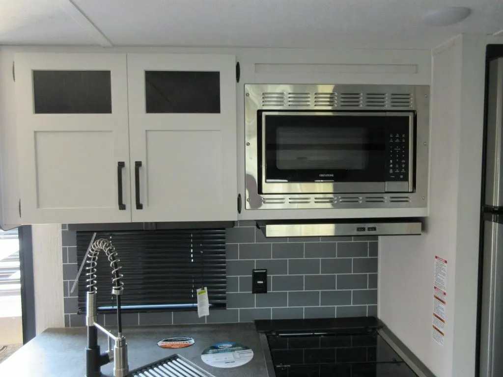 Kitchen with a gas burner, oven, sink and cabinets.