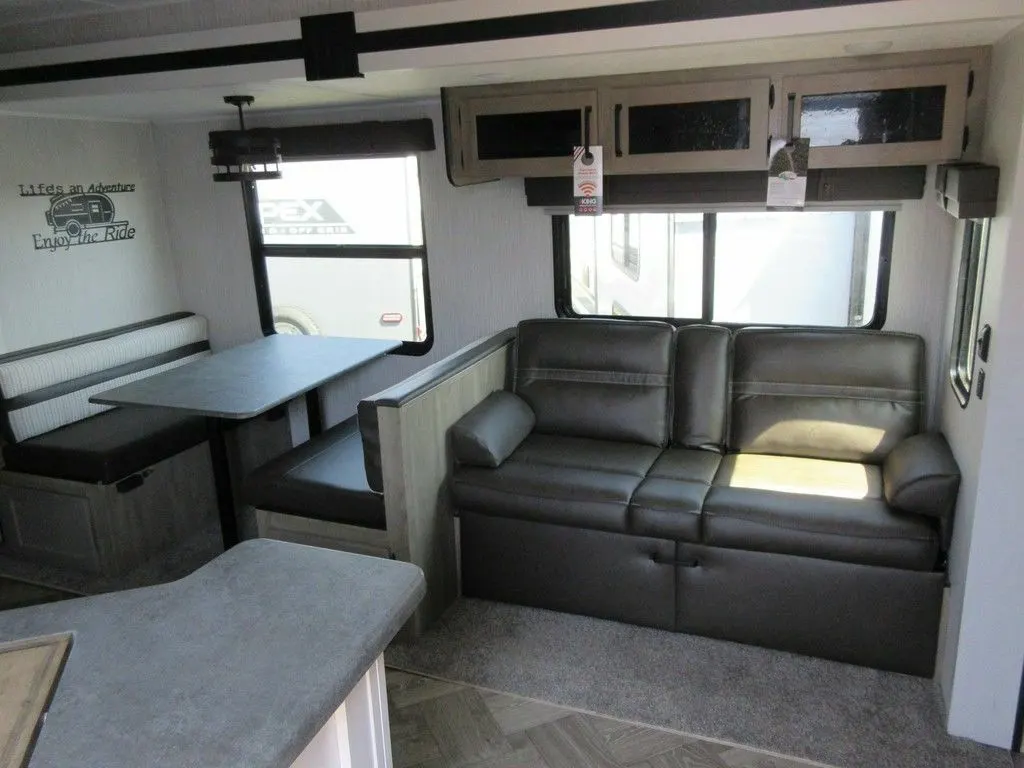 Interior view of the RV with a dinette and a living space.