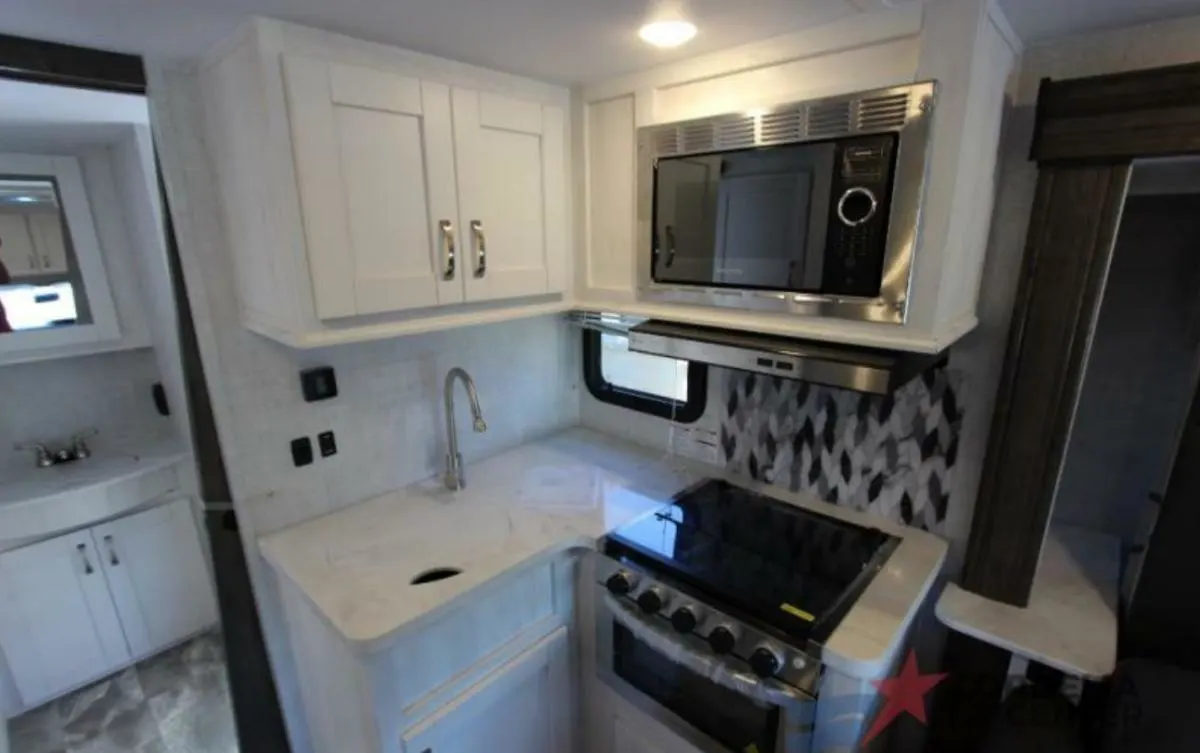 Kitchen with a gas burner, oven, sink and cabinets.