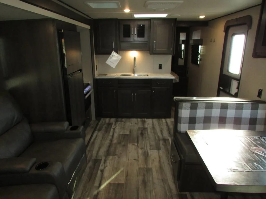 Interior view of the RV with a dinette, living space and a kitchen.