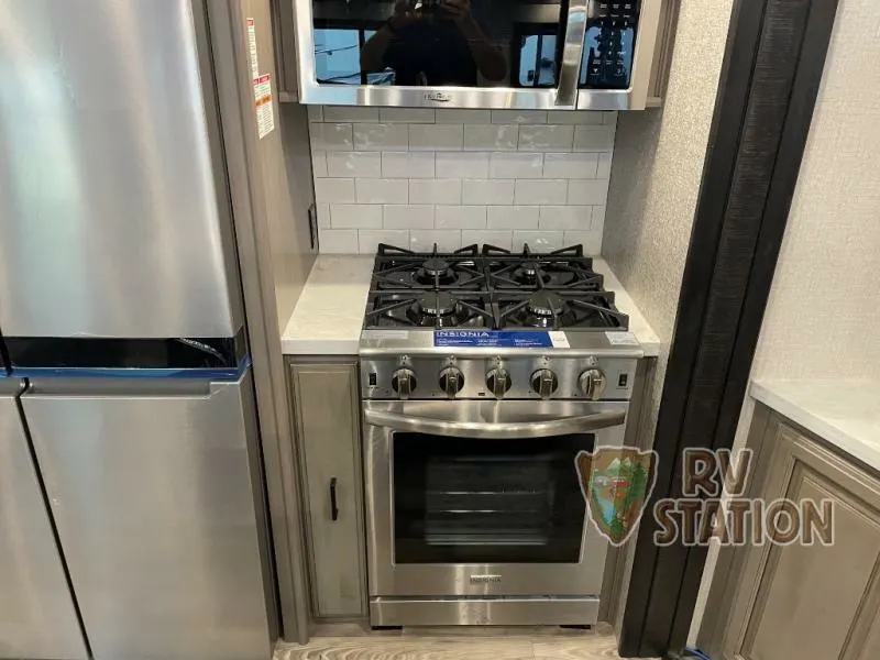 Kitchen with a gas burner, fridge, oven, and cabinets.