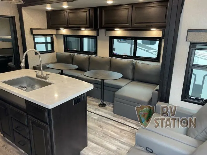 Interior view of the RV with a dinette, living space and a kitchen.