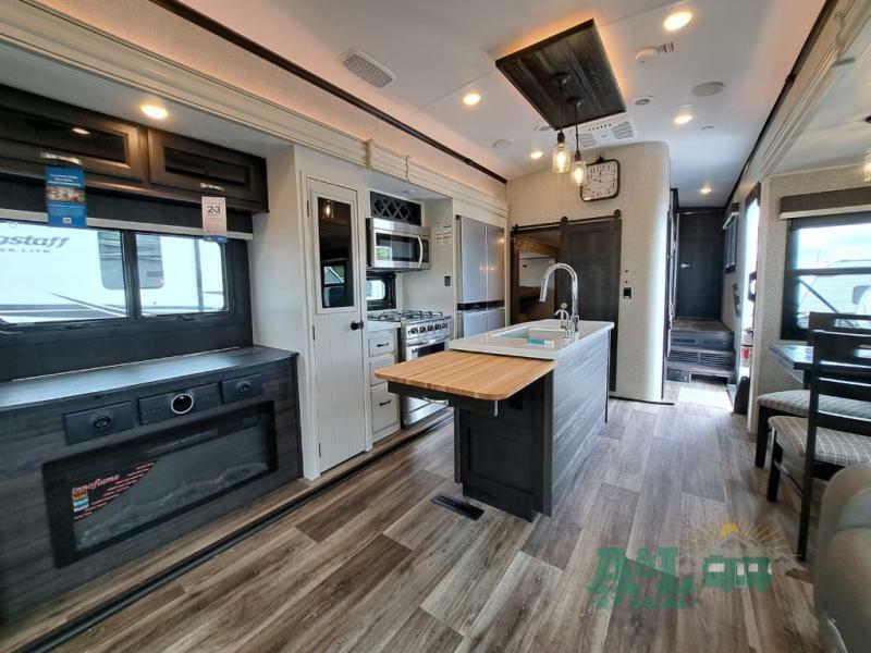 Interior view of the RV with a dinette, living space and a kitchen.