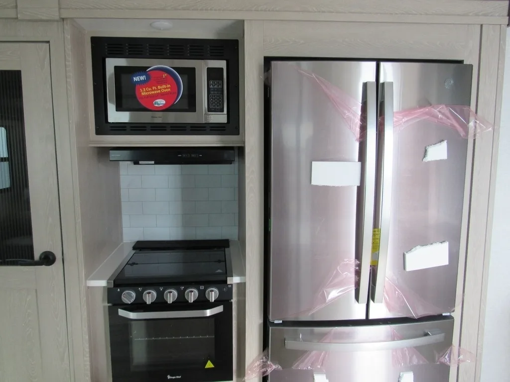 Kitchen with a gas burner, fridge, and oven.