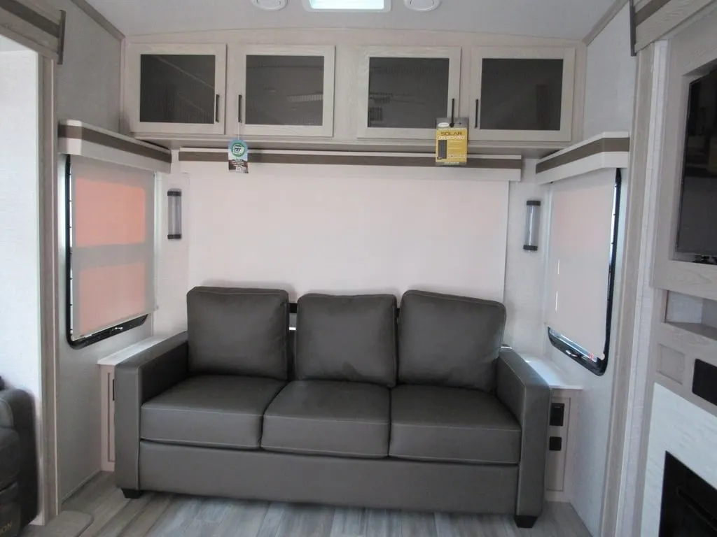 Living space with leather seats and overhead cabinets.