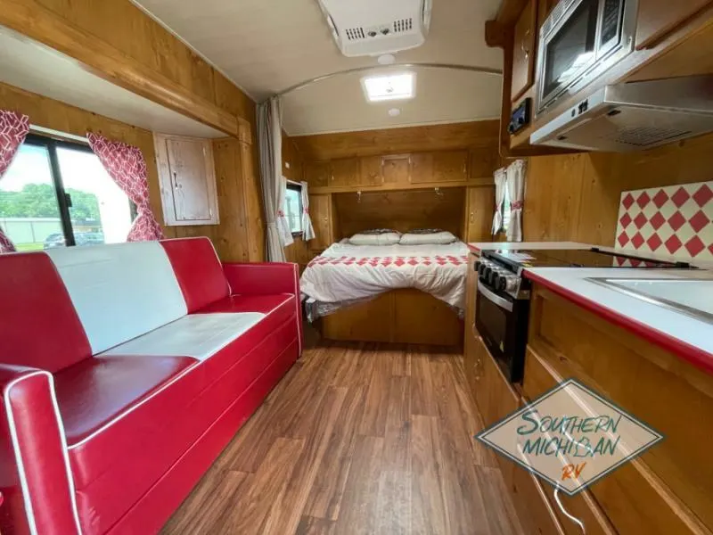 Interior view of the RV with a living space, bedroom and a kitchen.