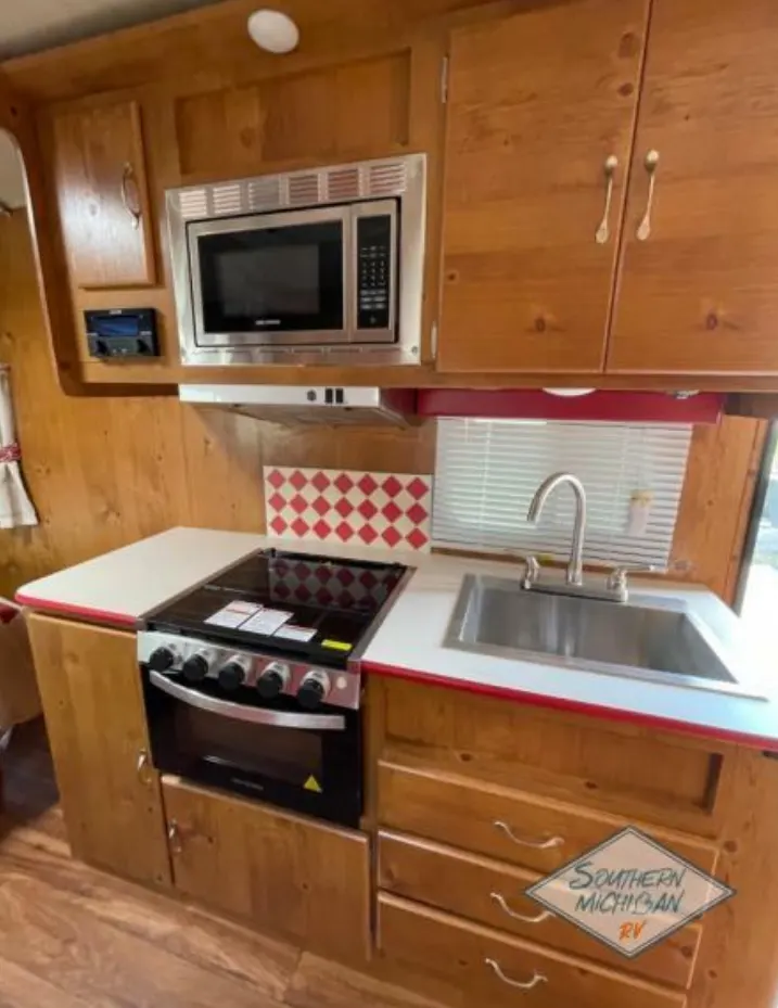 Kitchen with a gas burner, oven, sink and cabinets.