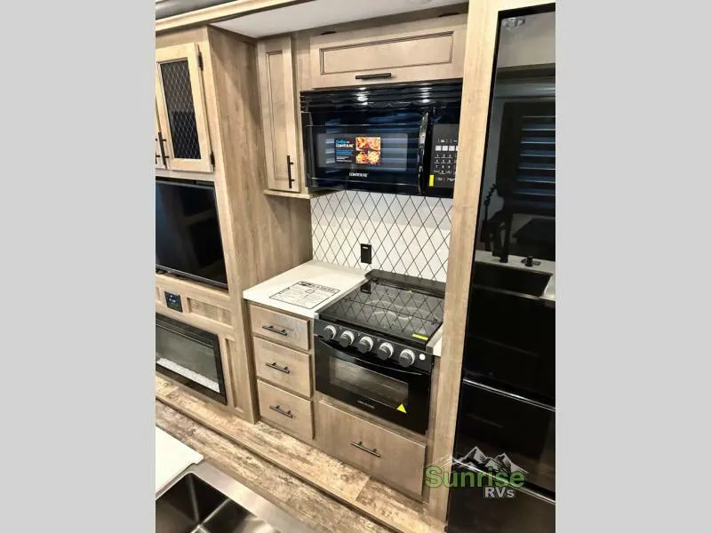 Kitchen with a gas burner, fridge, oven, and cabinets.