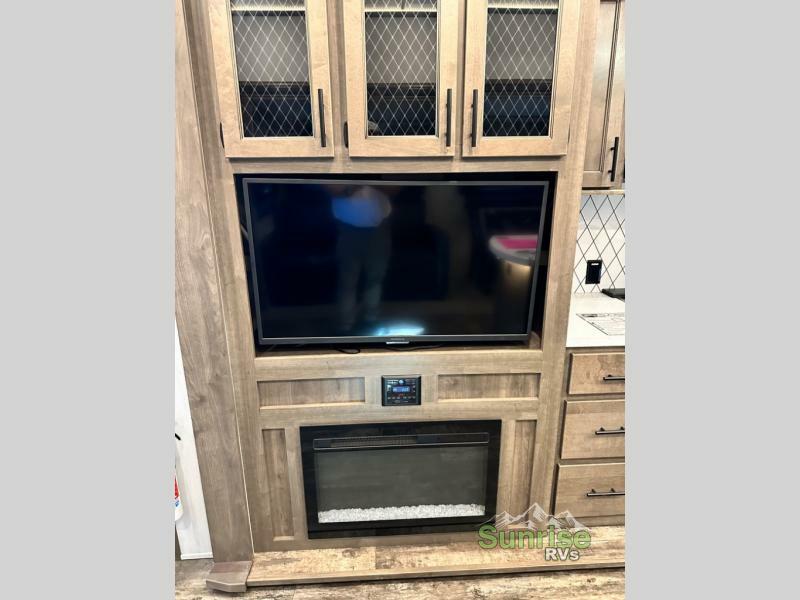 Entertainment center with a TV and a fireplace.