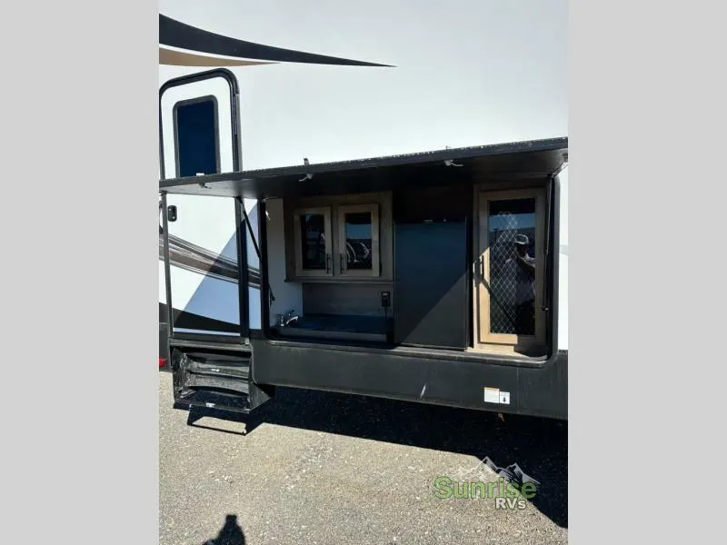 Outdoor kitchen with a fridge and a sink.