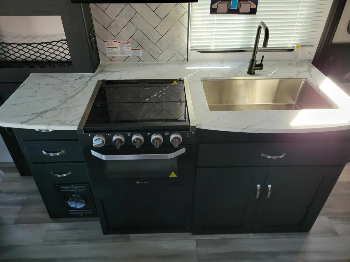 Kitchen with a gas burner, sink and cabinets.