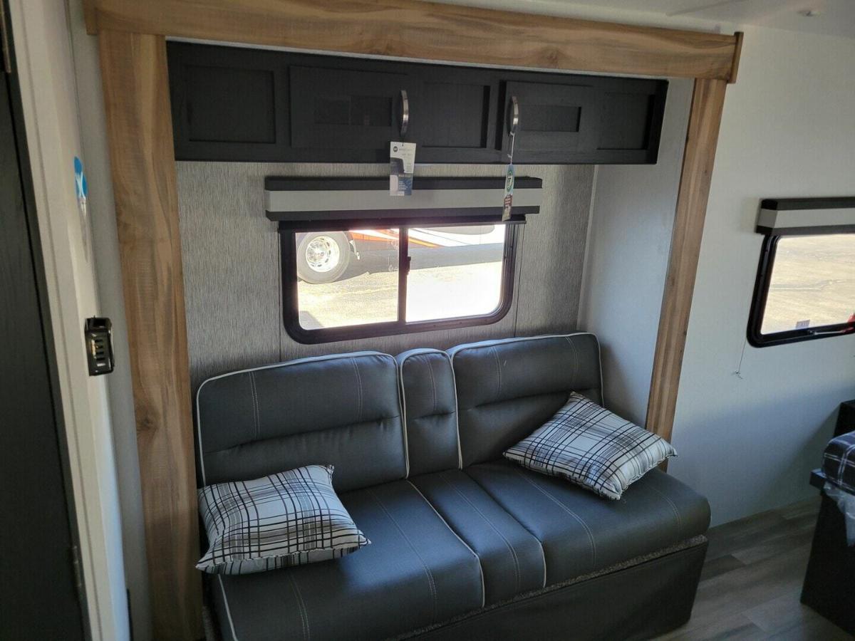 Living space with a sofa and overhead cabinets.