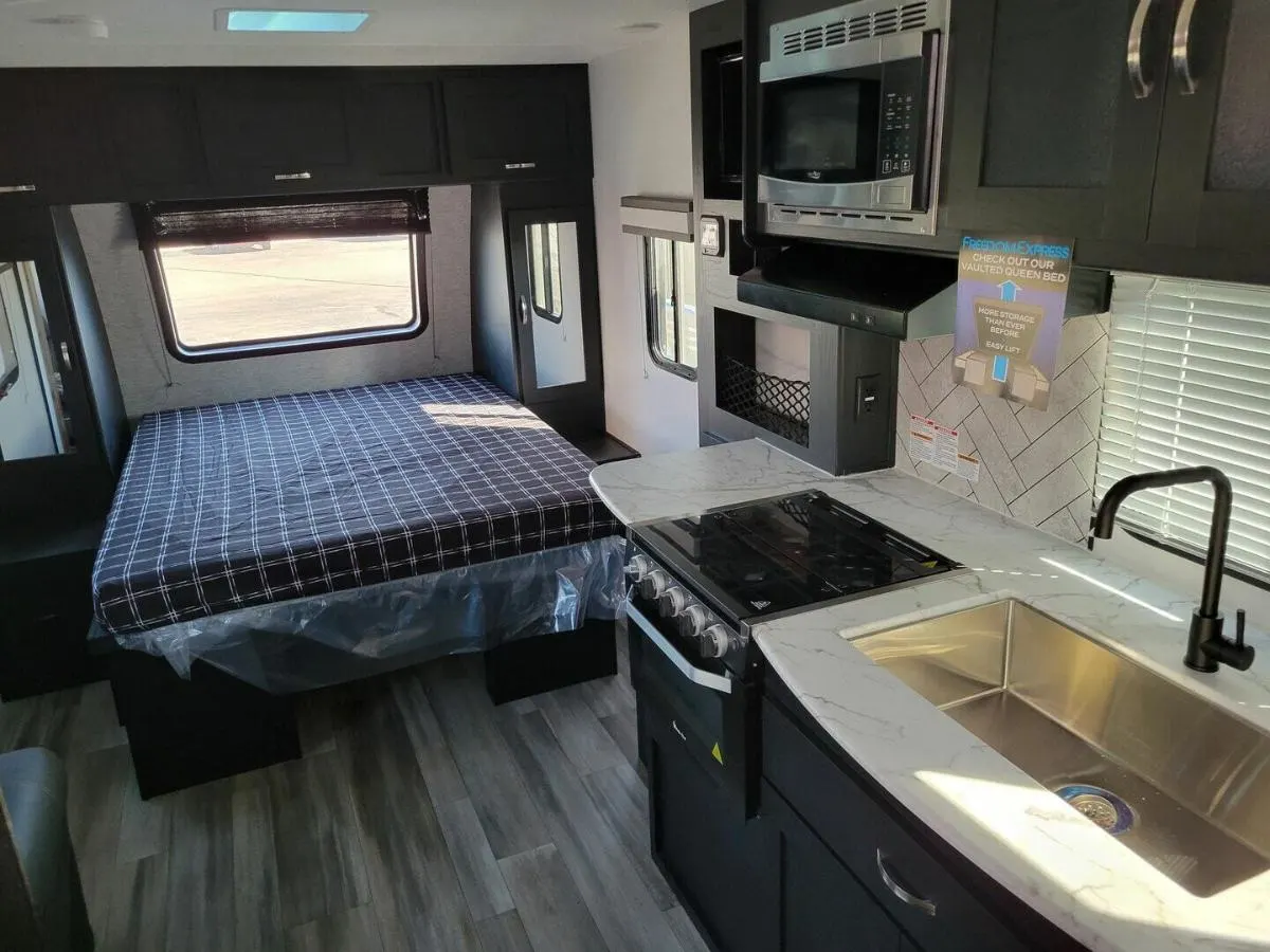 Interior view of the RV with a bedroom and a kitchen.