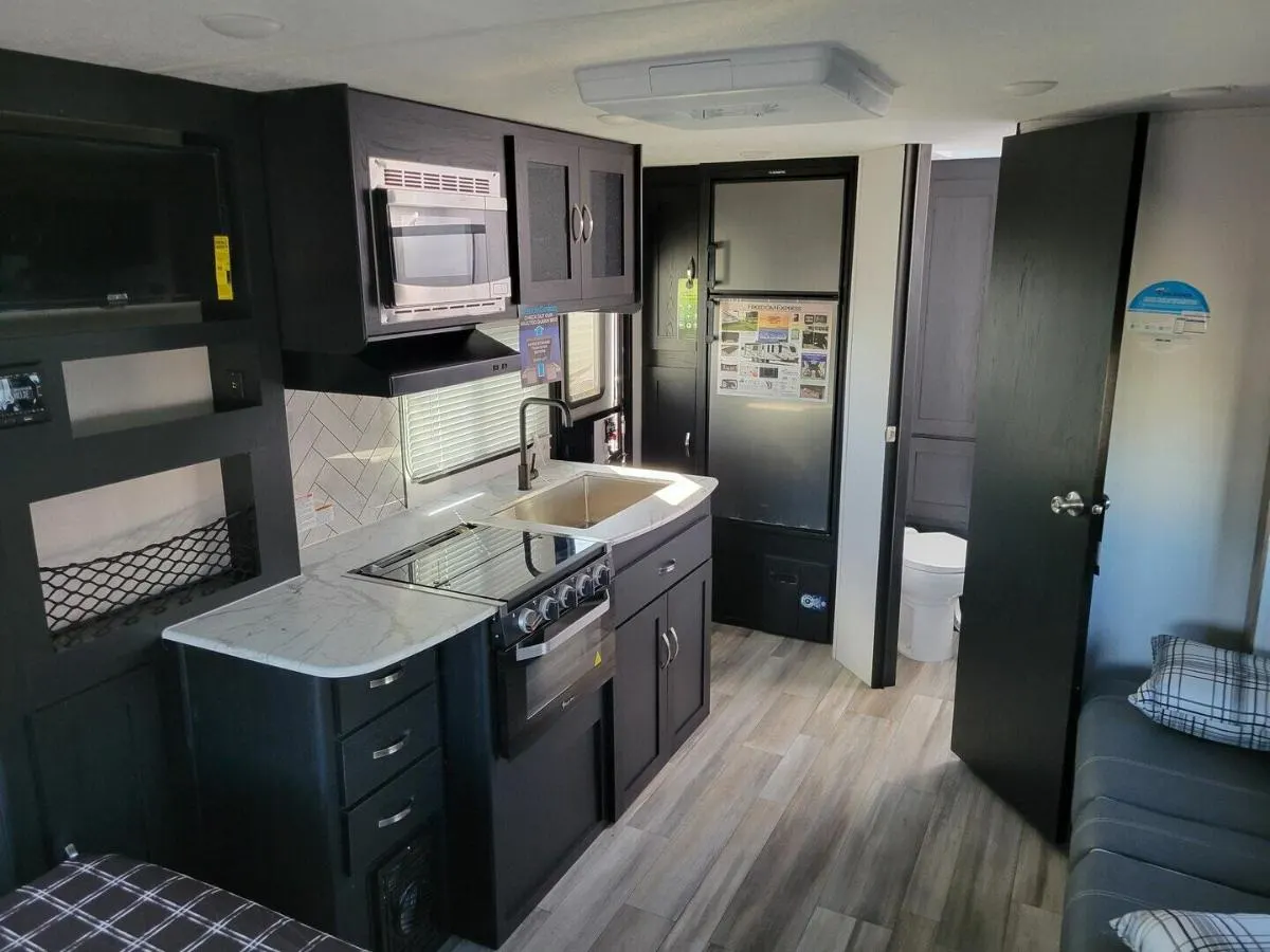 Kitchen with a gas burner, fridge, oven, sink and cabinets.