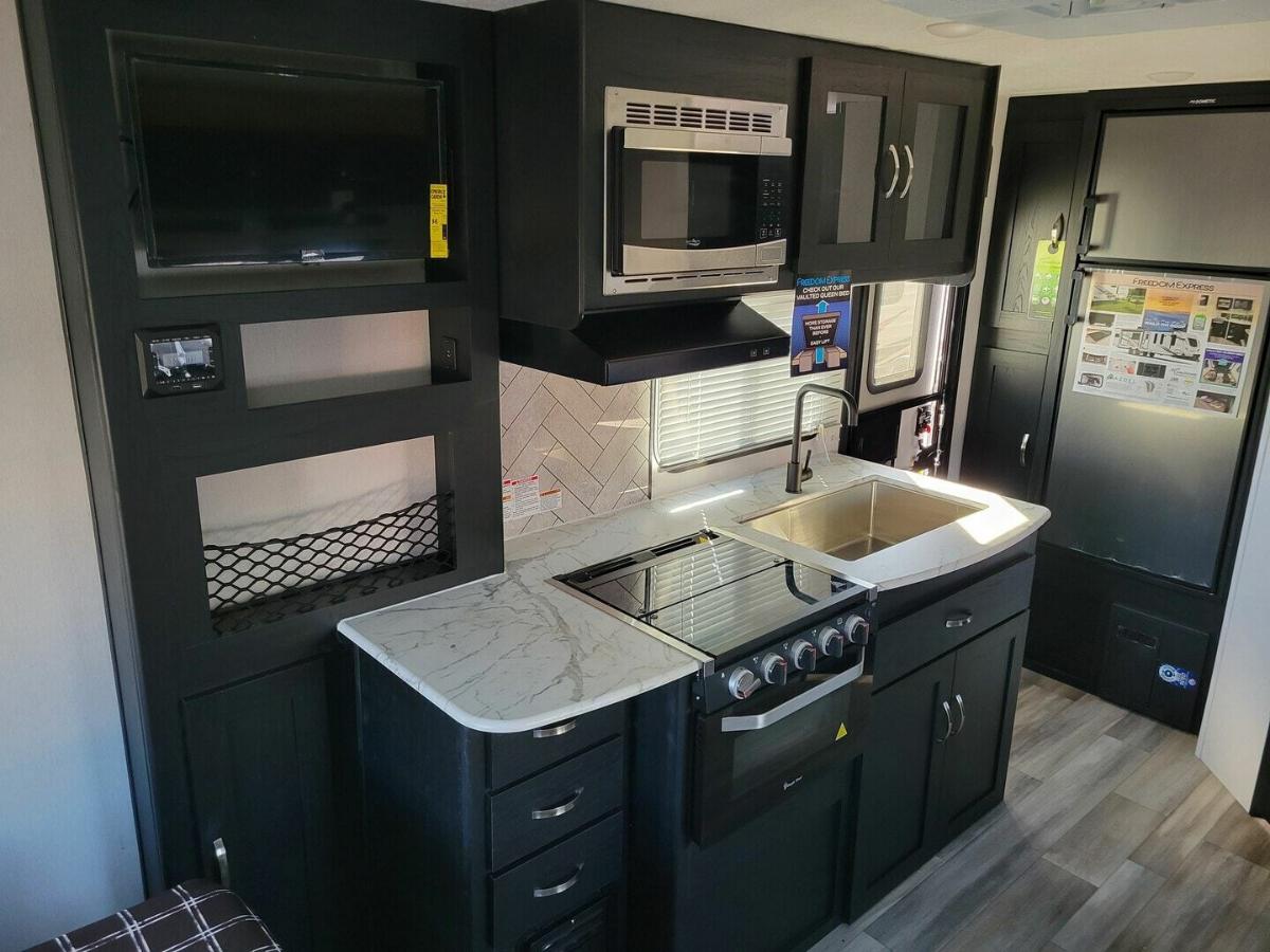 Kitchen with a gas burner, fridge, oven, sink and cabinets.