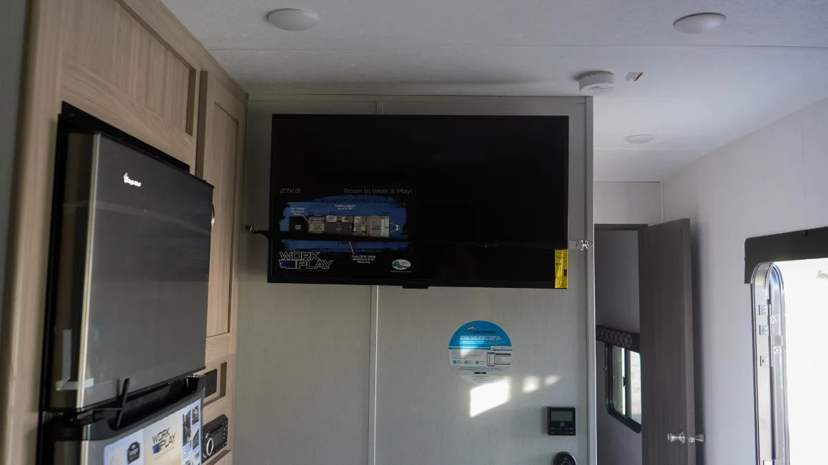 Wall-mounted TV and a fridge.