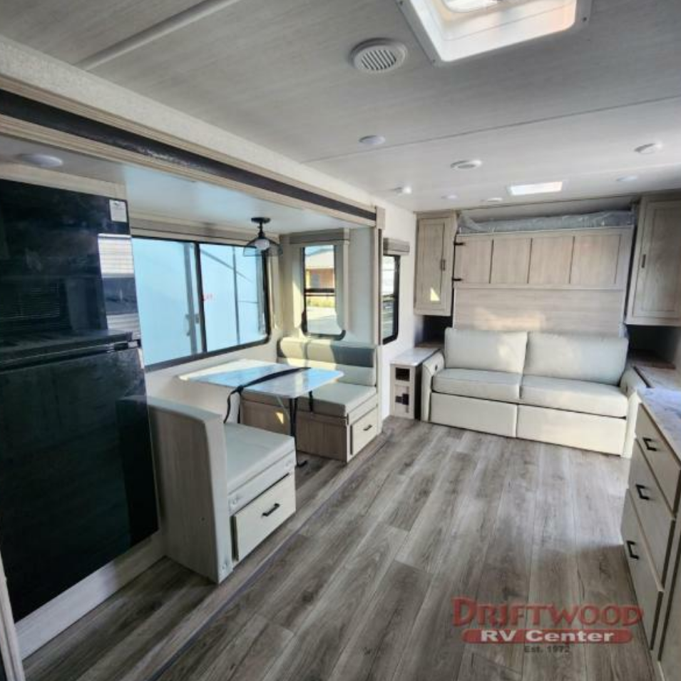 Interior view of the RV with a dinette and a living space.