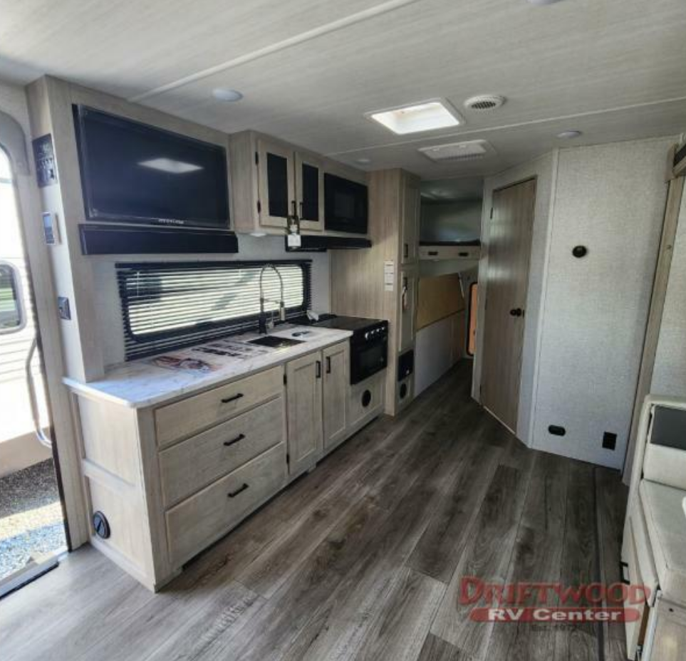 Kitchen with a gas burner, oven, sink and cabinets.