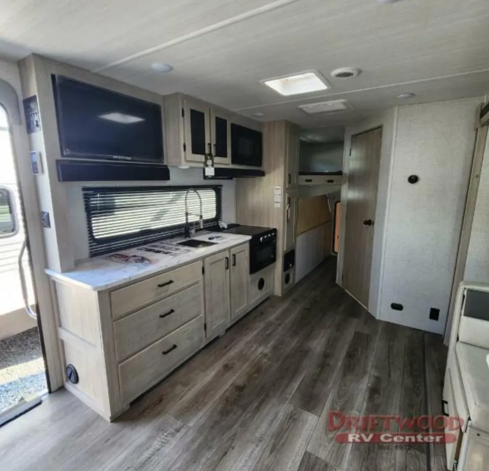 Kitchen with a gas burner, oven, sink and cabinets.