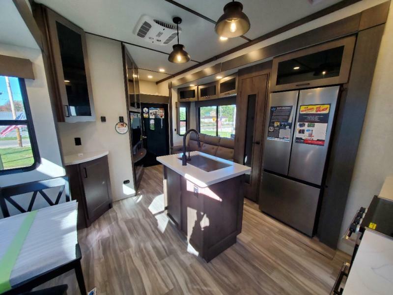 Interior view of the RV with a dinette, living space and a kitchen.