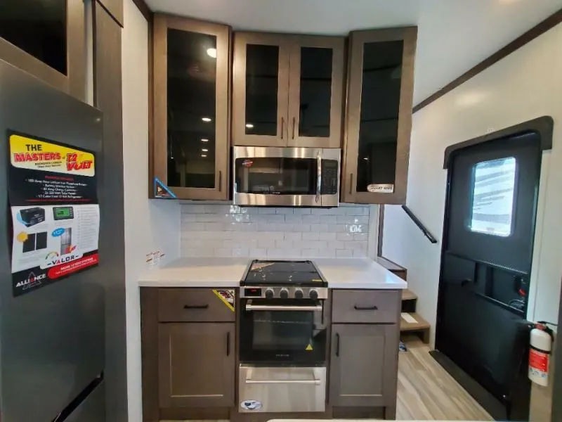 Kitchen with a gas burner, fridge, oven, and cabinets.