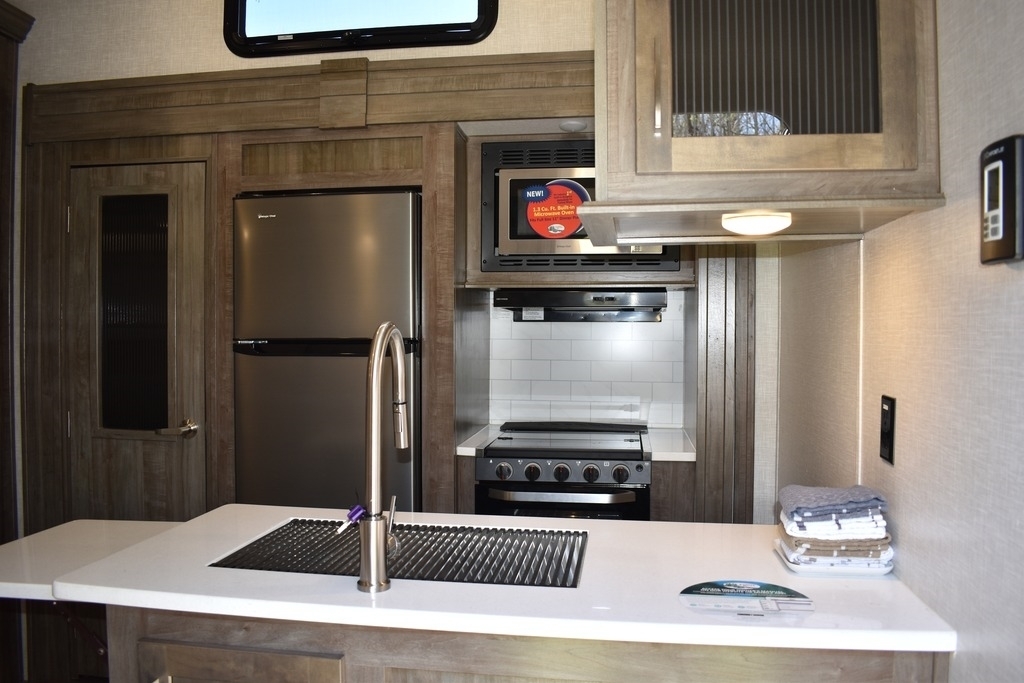 Kitchen with a gas burner, fridge, oven, sink and cabinets.