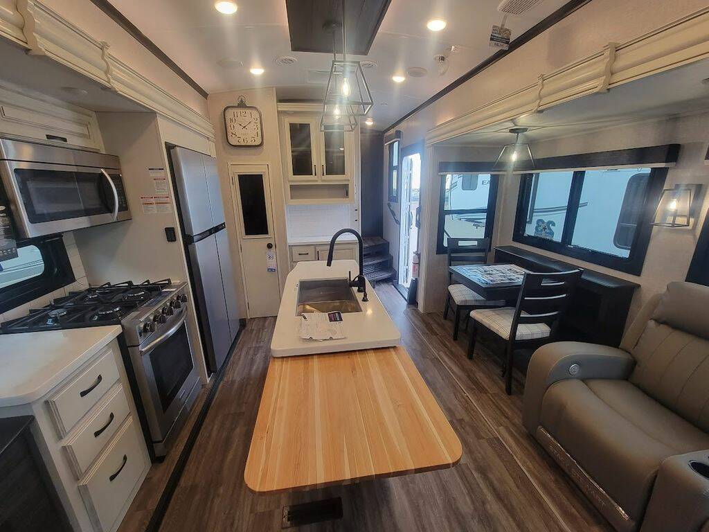 Interior view of the New 2023 Jayco NORTH POINT 310RLTS Fifth Wheel RV with dinette, living area, and kitchen. 