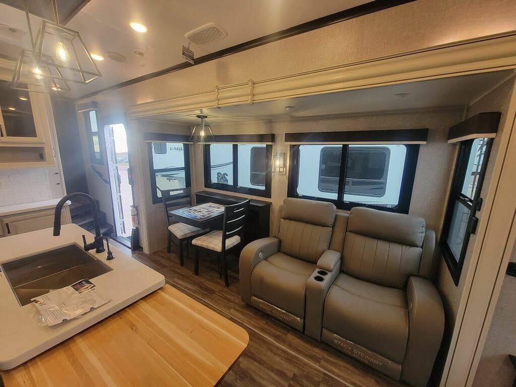 Interior view of the New 2023 Jayco NORTH POINT 310RLTS Fifth Wheel RV with dinette, living area, and kitchen. 