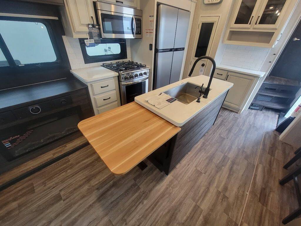 Kitchen with a gas burner, fridge, oven, sink and cabinets.