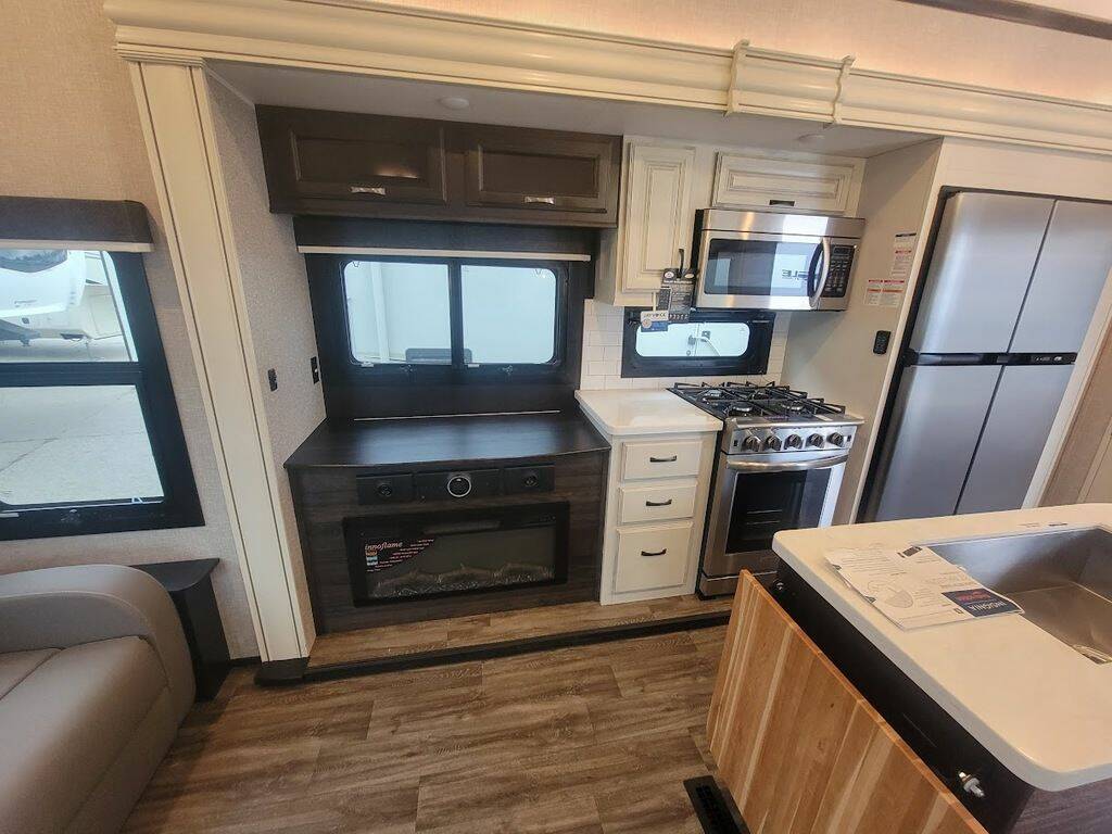 Kitchen with a gas burner, fridge, oven, sink and cabinets.