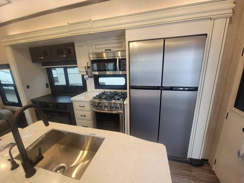 Kitchen with a gas burner, fridge, oven, sink and cabinets.