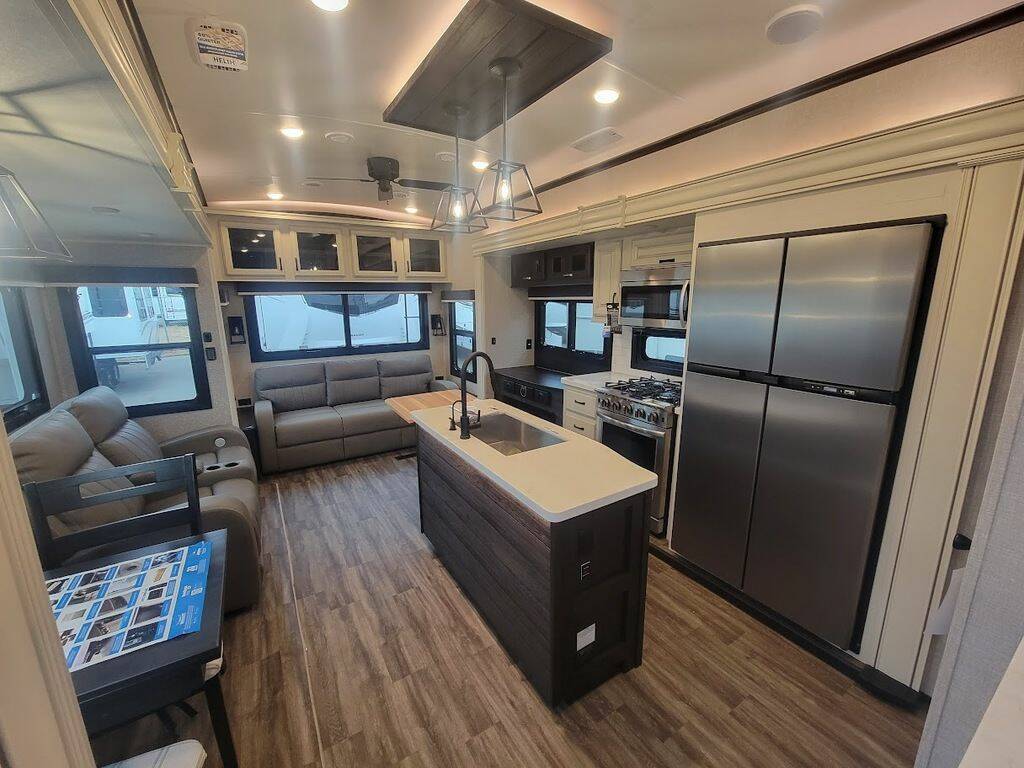 Interior view of the New 2023 Jayco NORTH POINT 310RLTS Fifth Wheel RV with dinette, living area, and kitchen. 