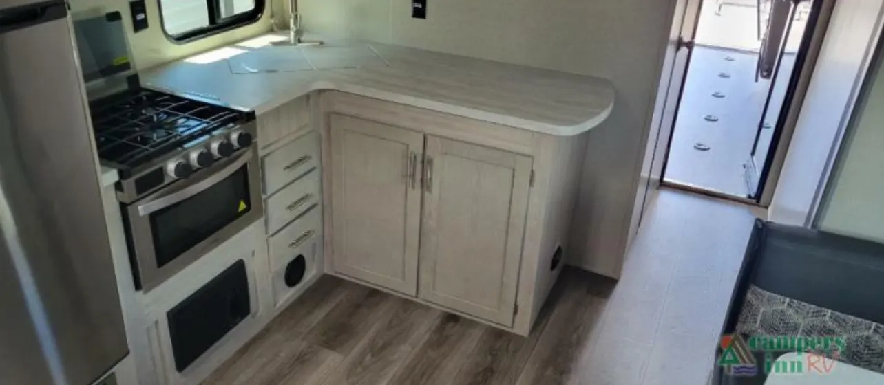 Kitchen with a gas burner, sink and cabinets.