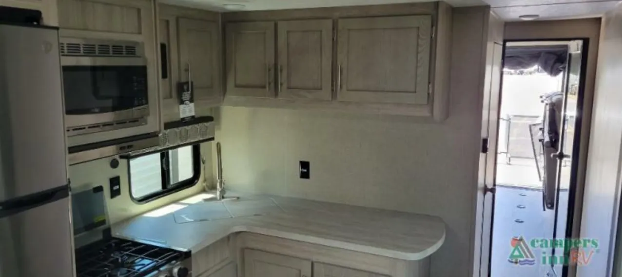 Kitchen with a gas burner, oven, sink and cabinets.