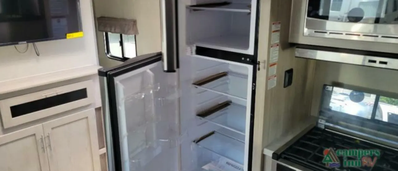 Kitchen with a gas burner, fridge, oven, and cabinets.