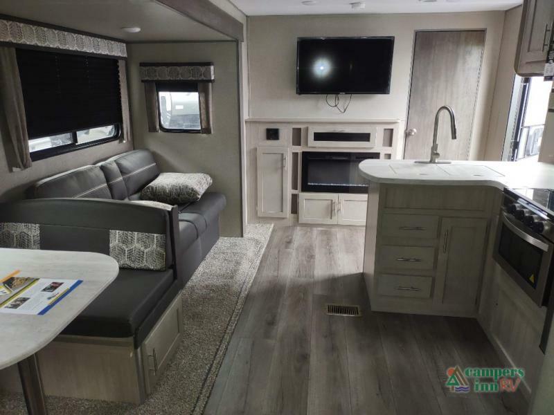 Interior view of the RV with a dinette, living space and a kitchen.