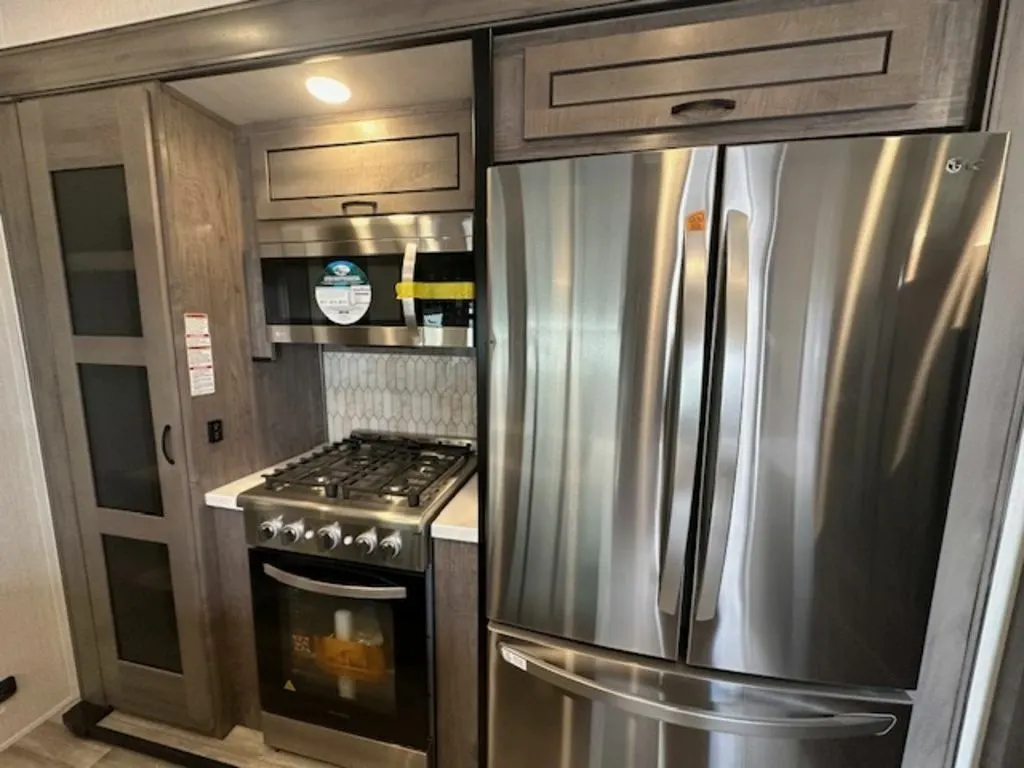 Kitchen with a gas burner, fridge, oven, and cabinets.