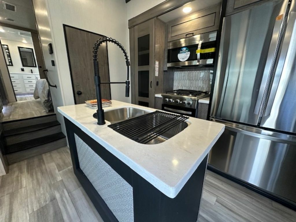 Kitchen with a gas burner, fridge, oven, sink and cabinets.